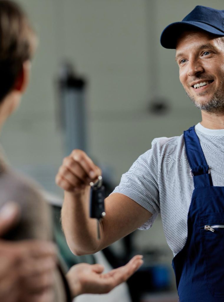 happy-auto-repairman-handing-cark-keys-his-customers-workshop