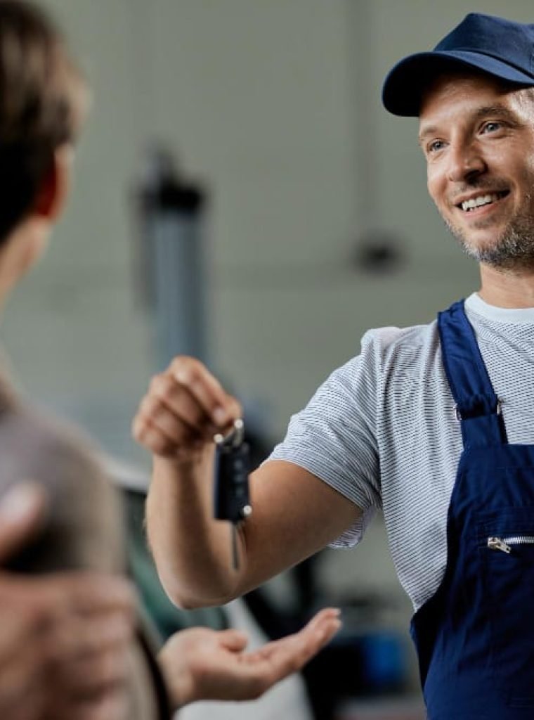 happy-auto-repairman-handing-cark-keys-his-customers-workshop